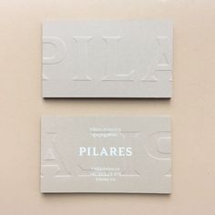 two business cards with the word pilares printed on them are sitting next to each other