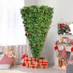 a christmas tree in the corner of a living room with presents on the floor next to it