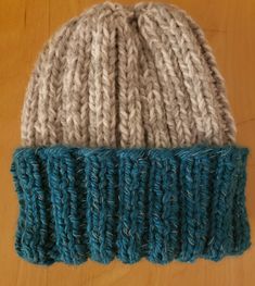 a knitted hat sitting on top of a wooden table