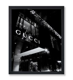 a black and white photo of a building with the word gucci lit up at night