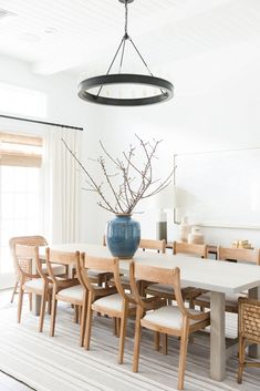 a dining room table with chairs and a vase on it