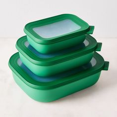 three green plastic containers stacked on top of each other with one empty container in the middle