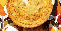 an overhead view of a cheese pizza on a table with plates and utensils