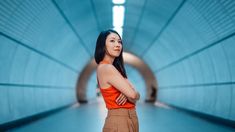 a woman standing in a tunnel with her hands on her hips and looking off to the side