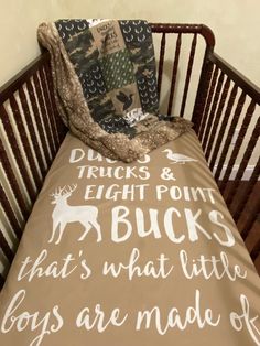 a baby crib with a brown and white comforter on it's side