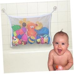 a baby sitting in a bathtub with stuffed animals hanging from the wall behind it