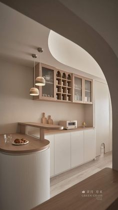 a kitchen with white cabinets and wooden counter tops, along with an arched doorway leading to the dining room