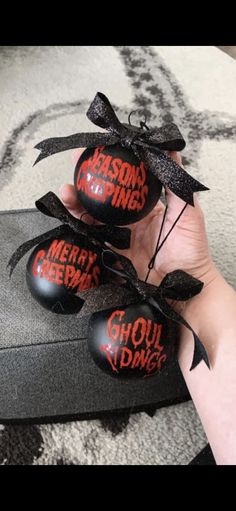 someone is holding three decorated eggs in their hand with the words merry christmas on them