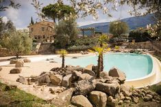 an outdoor swimming pool surrounded by rocks and trees