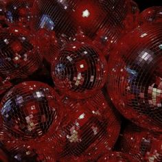 many shiny red disco balls are stacked together