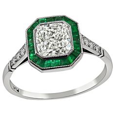 This is an elegant platinum engagement ring inspired from the Art Deco era. The ring is centered with a sparkling radiant cut diamond that weighs approximately 1.01ct. The color of the diamond is I-J with VS clarity. The center diamond is accentuated by lovely emerald and round cut diamond accents. The ring is stamped PLAT and weighs 3 grams. The ring is size 6 1/2 but it can be resized. Inventory #98630PEKS Art Deco Diamond Emerald Ring With Brilliant Cut, Art Deco Emerald Ring With Diamond Center Stone, Radiant Cut Emerald Diamond Ring With Center Stone, Art Deco Emerald Ring With Round Cut In Platinum, Classic Princess Cut Emerald Ring With Halo Setting, Radiant Cut Emerald Wedding Ring In Platinum, Platinum Emerald Ring With Radiant Cut For Wedding, Radiant Cut Emerald Platinum Wedding Ring, Classic Diamond White Emerald Ring With Brilliant Cut