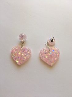 two pink heart shaped earrings with white and light pink sparkles on the ear wires