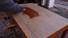 a person sanding wood on top of a wooden table