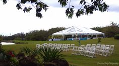 a large white tent set up with chairs and tables for an outdoor wedding or reception