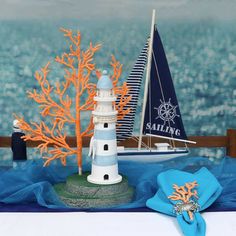 there is a small sailboat next to a lighthouse on the table with corals