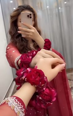 a woman taking a selfie with her cell phone wearing a red dress and flowered gloves