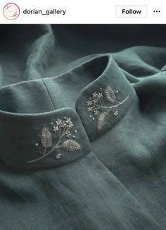 a close up of a shirt with embroidered flowers on the front and back of it