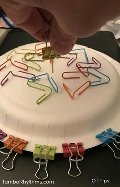 a paper plate that has some clothes pins on it and is being held by someone