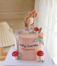 there is a pink cake with mushrooms and flowers on the top that says mom's smile mist