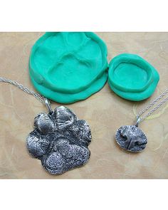 three pieces of jewelry sitting on top of a table next to an empty cookie sheet