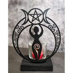 a candle holder with an image of a person holding a pen and surrounded by the moon