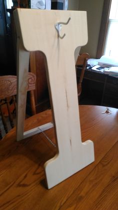 a wooden letter that is sitting on top of a table with a string attached to it