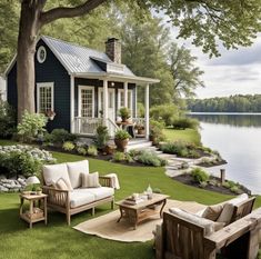 an outdoor living area with chairs, couches and tables in front of a lake