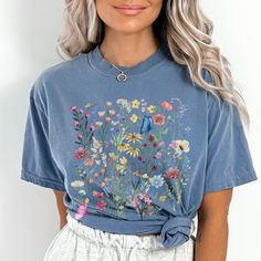 "floral shirt,wildflowers shirt,pressed flowers boho shirt,flower shirt,botanical shirt,gardening tee,cottagecore shirt, cottagecore flowers, Vintage Wildflowers,vintage floral shirt,Wild Flowers Shirt This nature design on an oversized t shirt will be a favourite for nature lovers and wildlife enthusiasts. Camping tshirt, hiking shirt. WILDFLOWERS TSHIRT, Cottagecore Shirt, Bug tshirt, Insect Shirt, Cottage tshirt, Cottagecore Shirt, Cottage Core Shirt *Comfort color garment dyed shirts are super popular right now and these cotton washed tees are the nicest, softest shirts to wear. The colors are true, amazing and gorgeous and will never pile. The double-needle stitching throughout the tee makes it highly durable while the lack of side-seams helps the shirt retain its tubular shape.  Shir Cottagecore Floral Embroidery Tops For Spring, Cottagecore Short Sleeve Top For Spring, Blue Floral Print Graphic Tee, Blue Graphic Tee With Floral Print, Blue Floral Print Graphic Tee Shirt, Spring Cottagecore Shirt With Graphic Print, Cottagecore Floral Embroidery T-shirt For Summer, Cottagecore Floral Embroidered T-shirt For Summer, Cottagecore Short Sleeve Tops With Floral Embroidery