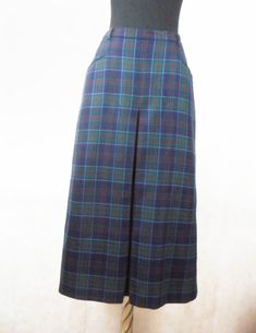 "A real classic vintage garment, beautifully made, elegant skirt by Daks London, plaid in dark blue, green and red. The two side pockets are lined in soft black leather, with full pleat front and back. full lining. This skirt even has small belt loops so you can wear a skinny tan leather belt. This is your perfect Autumn / Winter skirt. Marked: 100% pure new wool, Daks London, size 12 to fit hips 96 cm, made in Great Britain. Condition: in perfectly condition, looks new. Dimensions: Waist: 36cm High Waist Retro Pleated Skirt, Retro High-waist Fitted Skort, Retro High Waist Fitted Skort, Retro Green Long Skirt Bottoms, Retro Green Long Skirt, Classic Fitted Long Skirt, Hip-length Lined Skirt With Relaxed Fit, Retro Fitted Skirt With Pockets, Fitted Long Retro Skirt