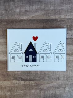 a card with houses and a red heart on it that says, my home is in the middle