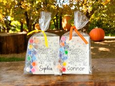 two bags filled with candy sitting on top of a wooden table