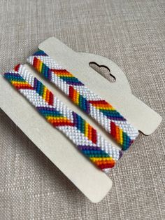 Rainbow alternating chevron pattern bracelet (1 bracelet per order).   Colors included: white or black base (customizable), red, orange, yellow, green, blue, and purple. The body of the bracelet is approximately 6 inches in length. Fits most wrists with a tie closure! Adjustable White Band Bracelet, White Band Jewelry Gift, Chevron Pattern Bracelet, Chevron Friendship Bracelet, Pattern Bracelet, Red Orange Yellow, Braided Bracelets, Chevron Pattern, Friendship Bracelet