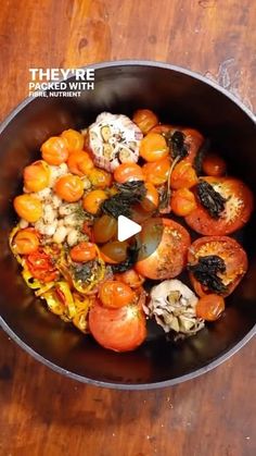 a pan filled with lots of different types of food on top of a wooden table