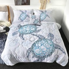 a bed with blue and white sea turtle comforter on it's coverlet