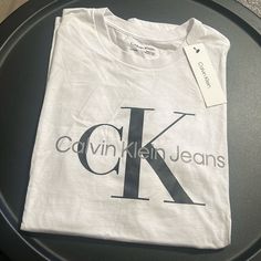 Calvin Klein Monogram Logo Crewneck T-Shirt White/ Black Nwt Classic Calvin Klein Crew Neck Top, Calvin Klein Logo Cotton Tops, Calvin Klein Cotton Logo Tops, Calvin Klein Cotton Tops With Logo, Calvin Klein Logo Print Crew Neck T-shirt, Calvin Klein Crew Neck T-shirt With Logo, Calvin Klein Cotton Logo T-shirt, Calvin Klein Cotton T-shirt With Logo Print, Calvin Klein Graphic T-shirt For Streetwear