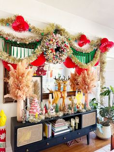 a christmas display in a living room decorated with red, white and green decorations on the mantle