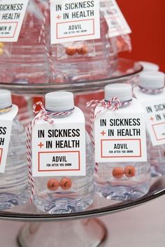 several bottles of water with labels on them sitting on a glass platter that says in sickness and in health