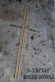 two wooden sticks laying on the ground next to a box with some paint and glue