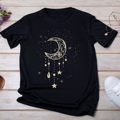 a black t - shirt with the moon and stars hanging from it's side