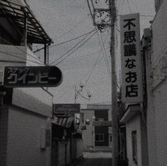 an alley way with signs on the buildings and telephone wires in the air above it