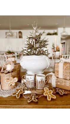 gingerbread cookies and christmas decorations on a wooden table in front of a small tree