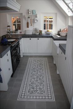 an image of a kitchen setting with white cabinets and black counter tops on the floor