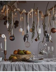 a table topped with lots of christmas ornaments and candles next to plates filled with food