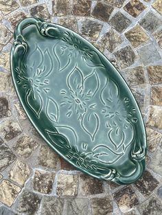 a green tray sitting on top of a stone floor