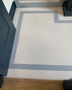 a bathroom with blue and white tiles on the floor next to a toilet in front of a door