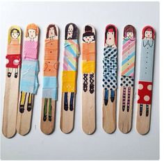 six wooden skis with different designs and people on them, lined up in a row