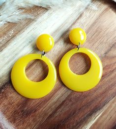 Retro 1950's Style Yellow Hoop Earrings. I have made these fabulous statement drop hoop earrings in resin, using retro yellow colouring. The drop hoops have a classic 1950's style and measure 42mm in diameter. They are fixed to the top studs which are 17mm in diameter and have a 6mm dome. They are finished with silver tone brass earring posts and have an total drop of 62mm. They are incredibly lightweight making them easy to wear. They will look amazing with your vintage dresses and also jeans and tops for a 50's rockabilly look. Please get in touch if you'd like these in a different colour combination, tops and hoops can be mixed or alternated if you would like mis-matched earrings. You can find more of my 50s and 60s drop hoop earrings here: www.etsy.com/uk/shop/RosieMays?section_id=2513 Lightweight Jewellery, Jeans And Tops, 80s Memories, Rockabilly Looks, Bold Statement Jewelry, 70s Vintage Fashion, 50s Rockabilly, Retro Yellow, Drop Hoop Earrings