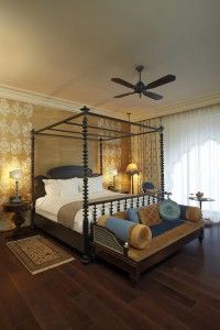 a bedroom with a four poster bed and wooden floors