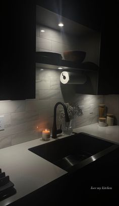 a kitchen sink sitting under a light next to a counter