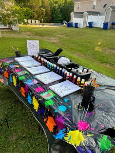 the table is covered with art supplies and has been set up for an outdoor event